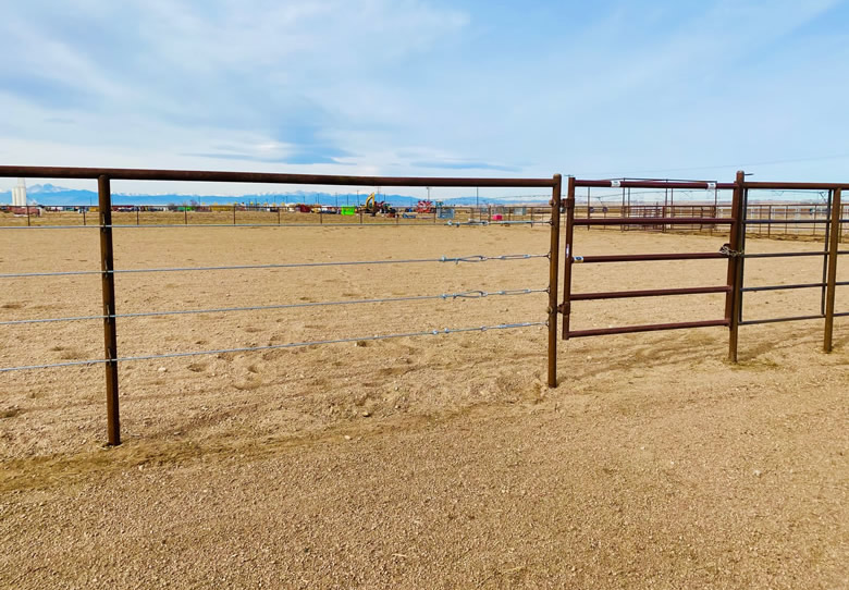Pipe and Cable Fencing for a Riding Arena, with 4 Strands of Galvanized cable. With a Continous Fence Tie Rail, with a gate for access to the arena. Construction by Integrity Welding Service LLC, servicing the Front Range of Colorado.